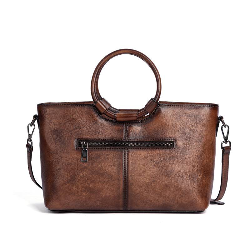 Sac en cuir bleu avec anses rondes, orné d’un médaillon illustrant un cerf stylisé, représentant le modèle Cervus Heritage