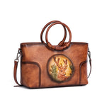 Sac en cuir bleu avec anses rondes, orné d’un médaillon illustrant un cerf stylisé, représentant le modèle Cervus Heritage
