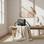 Sac bandoulière en cuir véritable noir, avec anse amovible et attaches à boucles dorées brillantes, format 26 × 20 × 10 cm.
