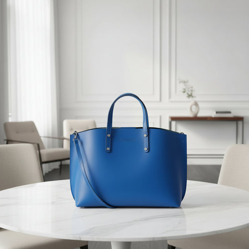Grand sac à main en cuir véritable bleu royal, avec bandoulière amovible, pochette interne extractible et finitions canon de fusil brillantes, format 48 × 31 × 11 cm.