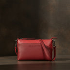 Pochette en cuir rouge lisse au format compact, dotée d’une fine bandoulière et pensée pour accompagner élégamment une soirée. 